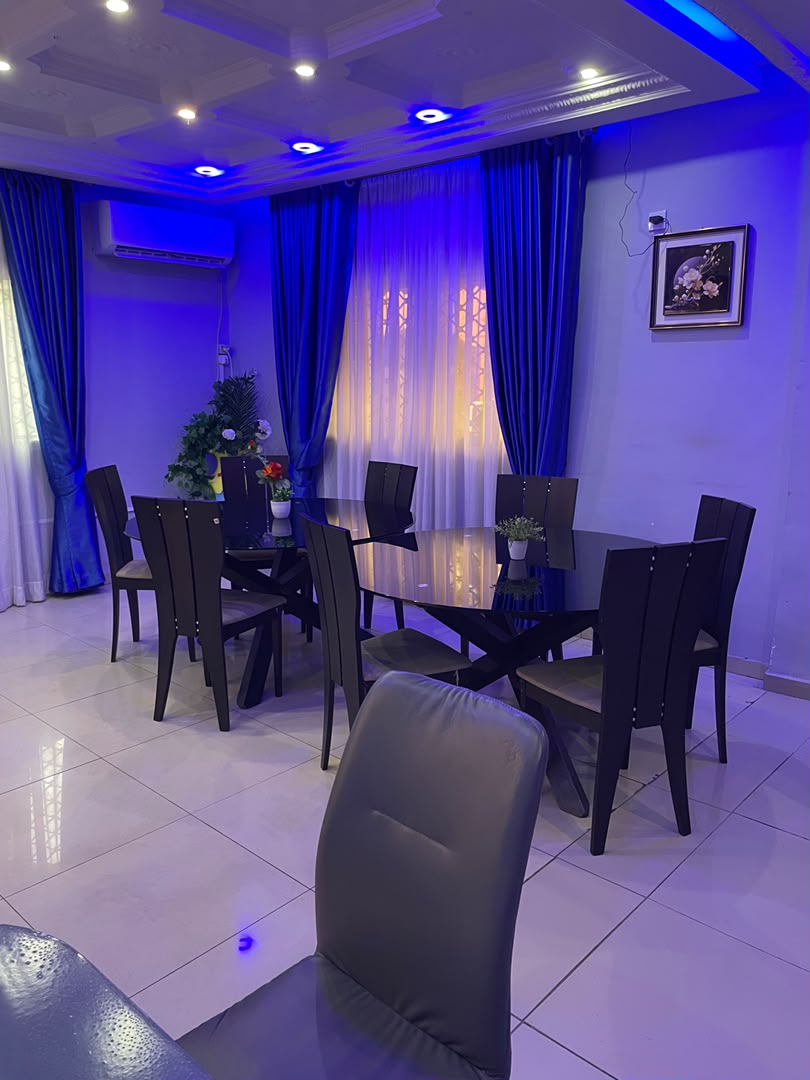 Salle à manger intérieure et sa grande table ovale, éclairage bleu