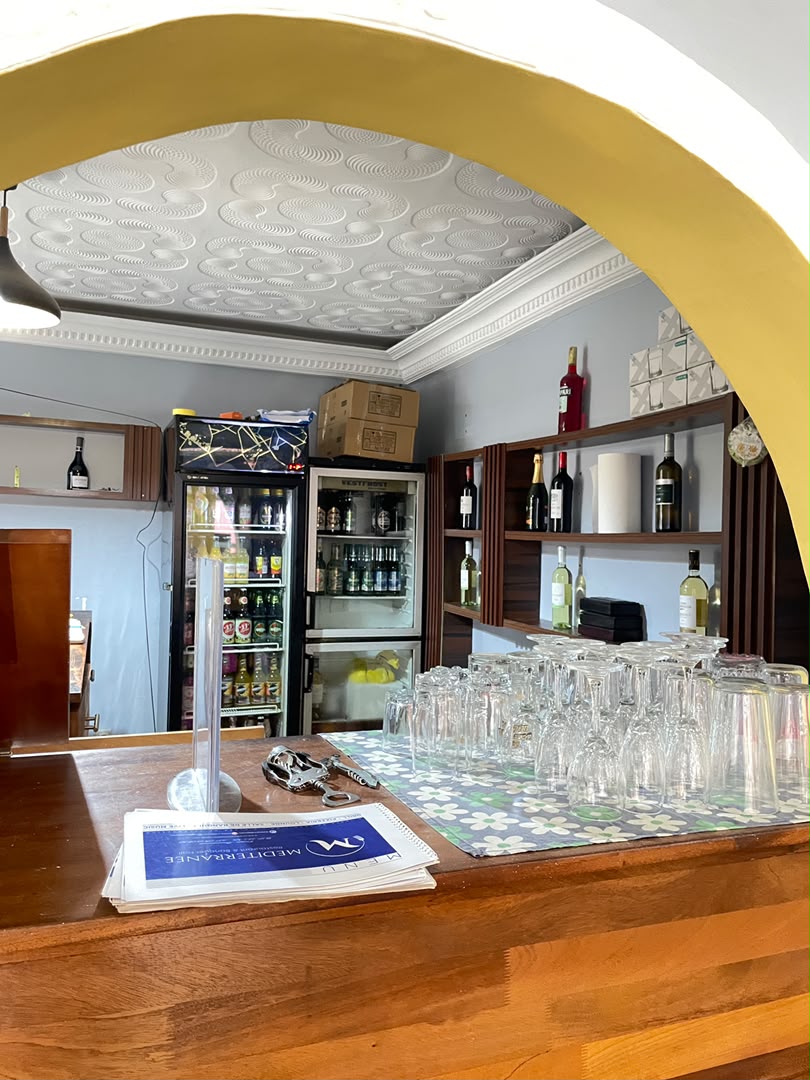 Le bar du restaurant et sa verrerie sous l'arche jaune